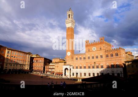 Turm von Mangia und Pubblico Palast (Rathaus) glühend rot kurz vor Sonnenuntergang auf der Piazza del Campo, Siena, Toskana, Italien Stockfoto