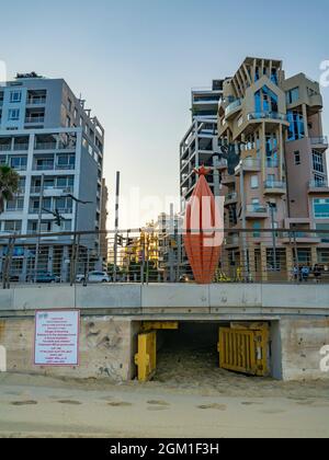 Tel Aviv, Israel - 20. August 2021: Ein Eingang zu einem Entwässerungstunnel unter den Gebäuden von Tel Aviv, Israel, mit einem mehrsprachigen Warnschild. Stockfoto