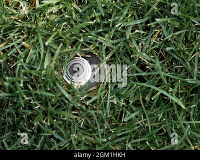 Automatischer Gartenrasenregner auf einem Hintergrund aus Gras. Stockfoto