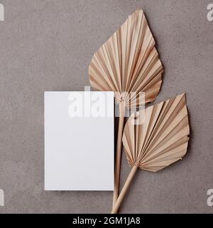 Leere Einladungskarte für eine natürliche Hochzeit oder Feier mit getrocknetem Palmblatt-Stiel Stockfoto