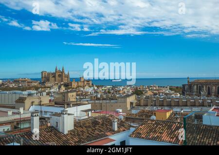 Stadtansicht von Palma Mallorca mit der Kathedrale und dem Meer im Hintergrund. Im Vordergrund schöne Dächer traditioneller spanischer Häuser. Stockfoto