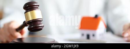 Richter hält Richter hölzernen Gavel vor dem Hintergrund des Hauses und Dokumente Stockfoto