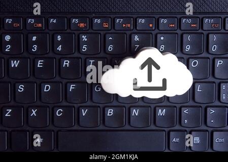 Technologie, Cloud-Computing-Konzept. Weiße Wolke mit Upload-Symbol auf der Tastatur Stockfoto