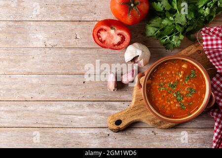 Rote Linsensuppe in Schüssel auf Holztisch Stockfoto