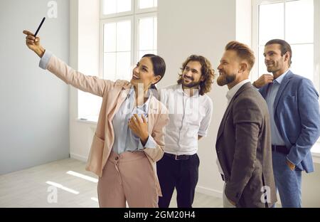 Lächelnde, vielfältige Mitarbeiter machen ein Selbstporträt auf der Zelle Stockfoto