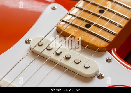 Detail des Halses, des Pickups und der Saiten einer roten E-Gitarre Stockfoto