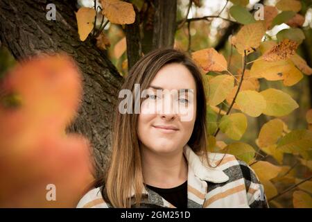 Fallen. Porträt einer jungen schönen Frau in einem gelben Herbstwald. Stockfoto