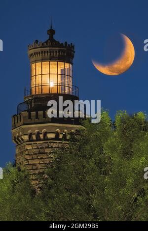 NAVESINK Twin Lights - Nahaufnahme eines der beleuchteten Leuchttürme mit dem unterschellenden Mond. Der heutige Leuchtturm wurde 186 errichtet Stockfoto