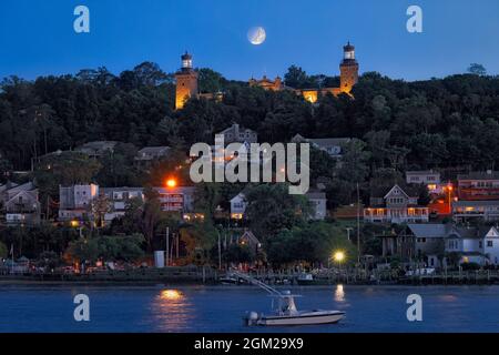 Moonset Navesink Twin Lights - Blick in die Dämmerung auf die beleuchteten Leuchttürme mit dem untergehenden Mond zwischen den Türmen. Die aktuellen Leuchttürme were Stockfoto