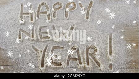 Schneeflocken fallen gegen Happy New Year Text im Schnee geschrieben Stockfoto