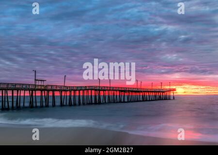 Virginia Beach Pier - die Sonne geht am Virginia Beach Fishing Pier auf und bietet den Zuschauern atemberaubende Farben. Dieses Bild ist auch als BL verfügbar Stockfoto