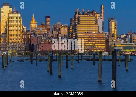 NY Life NYC - Blick in die Dämmerung auf den beleuchteten Hauptsitz des NY Life Insurance Building. Die goldenen warmen Töne der untergehenden Sonne im Westen sind Stockfoto