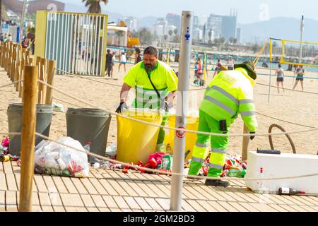 BARCELONA, SPANIEN - 05. Mai 2021: Die Mitarbeiter der Strandreinigung reinigen Müllcontainer am Strand von Barceloneta in Spanien Stockfoto