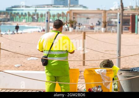 BARCELONA, SPANIEN - 05. Mai 2021: Die Mitarbeiter der Strandreinigung reinigen Müllcontainer am Strand von Barceloneta in Spanien Stockfoto