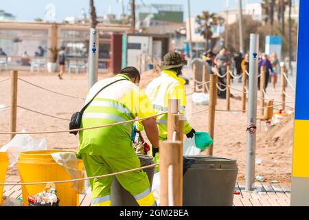 BARCELONA, SPANIEN - 05. Mai 2021: Die Mitarbeiter der Strandreinigung reinigen Müllcontainer am Strand von Barceloneta in Spanien Stockfoto