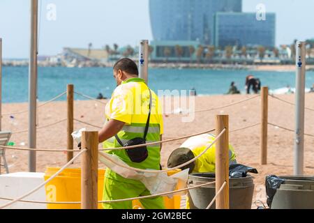 BARCELONA, SPANIEN - 05. Mai 2021: Die Mitarbeiter der Strandreinigung reinigen Müllcontainer am Strand von Barceloneta in Spanien Stockfoto