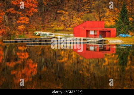 Boat House Fall - die schönen Farben des Herbstes spiegeln sich in den stillen Gewässern von Sheppard Pond und durch-out im Ringwood State Park in New Jers Stockfoto