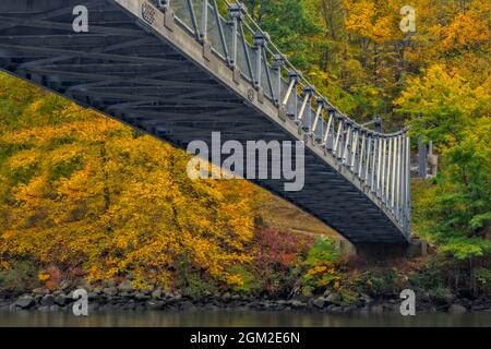 Popolopen Foot Bridge - Blick unter der Popolopen-Fußgängerbrücke, dem Hudson River und dem Bear Mountain State Park im Herbst mit seiner herrlichen Aussicht Stockfoto