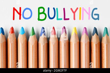 Bunte Holzkreidestifte in einer Reihe ohne Mobbing Nachricht geschrieben mit bunten Buchstaben an der Spitze. Um Mobbing an Schulen zu verhindern oder zu stoppen Stockfoto