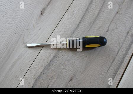 Ein generischer Schraubendreher auf Eichenholzplatten Stockfoto