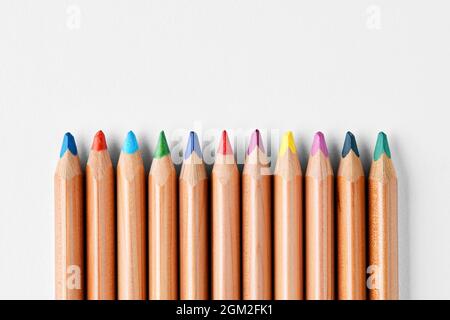 Bunte Holzstifte in einer Reihe auf weißem Hintergrund mit Kopierfläche. Zurück zum Schulkonzept. Stockfoto