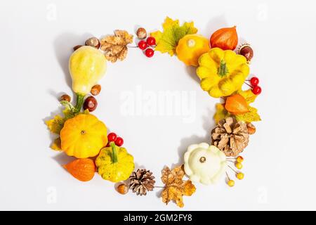 Herbstkranz aus Kürbissen, Zapfen, Nüssen, Herbstblättern und Beeren isoliert auf weißem Hintergrund. Kreative flache Lay-Komposition, die handgemachte. Inneneinrichtung Stockfoto