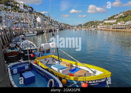 Angeschobene Boote aller Art am Kai in West Looe in Cornwall. In der Ferne Looe Bridge und der Fischmarkt über den Fluss in East Looe. Stockfoto