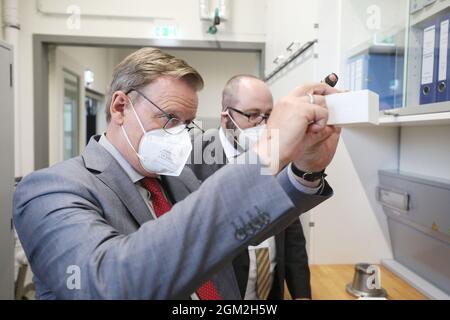 Hermsdorf, Deutschland. September 2021. Bei der Eröffnung des Pilotzentrums für Pulversynthese und Extrusion blickt Thüringens Ministerpräsident Bodo Ramelow (die Linke) durch eine Aluminiumwabe. Der von Bund und Freistaat Thüringen geförderte 550 Quadratmeter große Neubau ist für Forschungsarbeiten auf dem Gebiet der keramischen Membranen und der stationären Energiespeicherung vorgesehen. Quelle: Bodo Schackow/dpa-zentralbild/ZB/dpa/Alamy Live News Stockfoto