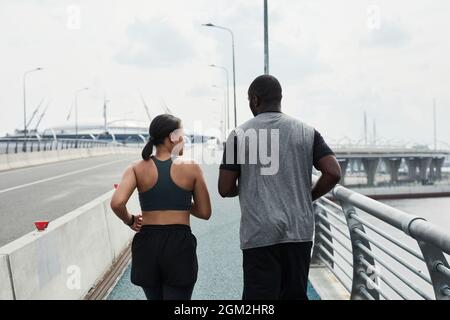 Rückansicht des jungen afrikanischen Paares, das morgens draußen läuft Stockfoto