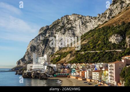 Blick am Morgen auf den Strand der katalanischen Bucht mit Caleta Hotel und anderen bunten Wohngebäuden gegen den Felsen von Gibraltar Stockfoto