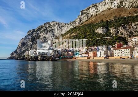 Blick am Morgen auf den Strand der katalanischen Bucht mit Caleta Hotel und anderen bunten Wohngebäuden gegen den Felsen von Gibraltar Stockfoto