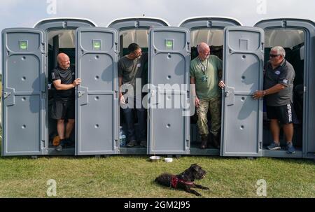 Veteranen (von links nach rechts), Ian Baillie, Mike Hewlett und sein Hund Buster, Gary Sprakes und Chris Nicholls, die 120 Stunden in tragbaren Toilettenkabinen auf dem Southsea Common in Portsmouth, Hampshire, verbringen, um Geld für Forgotten Veterans UK zu sammeln, das ehemalige Mitglieder der Streitkräfte unterstützt. Die Veteranen der Armee und des Royal Navy Submarine Service, die £1,500 sammeln wollen, begannen ihre Sit-in am Mittwoch und werden am Sonntag um 16 Uhr enden. Bilddatum: Donnerstag, 16. September 2021. Stockfoto