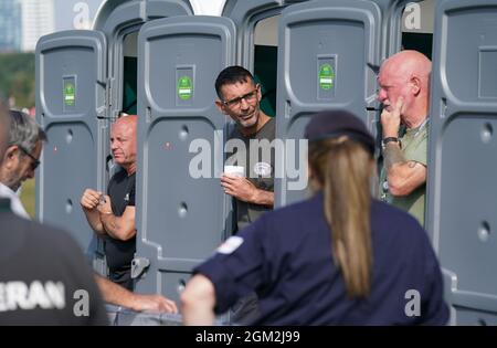 Die Veteranen Ian Baillie (links), Mike Hewlett und Gary Sprakes unterhalten sich mit Mitgliedern der Öffentlichkeit, während sie 120 Stunden in tragbaren Toilettenkabinen auf dem Southsea Common in Portsmouth, Hampshire, verbringen, um Geld für Forgotten Veterans UK zu sammeln, das ehemalige Mitglieder der Streitkräfte unterstützt. Die Veteranen der Armee und des Royal Navy Submarine Service, die £1,500 sammeln wollen, begannen ihre Sit-in am Mittwoch und werden am Sonntag um 16 Uhr enden. Bilddatum: Donnerstag, 16. September 2021. Stockfoto