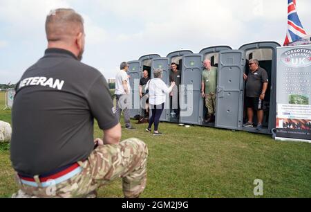 Die Veteranen Ian Baillie, Mike Hewlett und sein Hund Buster, Gary Sprakes und Chris Nicholls unterhalten sich mit Mitgliedern der Öffentlichkeit, während sie 120 Stunden in tragbaren Toilettenkabinen am Southsea Common in Portsmouth, Hampshire, verbringen, um Geld für Forgotten Veterans UK zu sammeln, das ehemalige Mitglieder der Streitkräfte unterstützt. Die Veteranen der Armee und des Royal Navy Submarine Service, die £1,500 sammeln wollen, begannen ihre Sit-in am Mittwoch und werden am Sonntag um 16 Uhr enden. Bilddatum: Donnerstag, 16. September 2021. Stockfoto