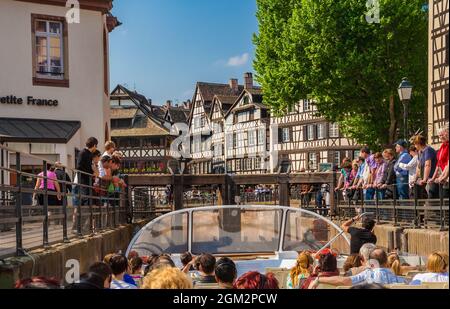 Schöne Aussicht auf das Straßburger historische Viertel „La Petite France“ von einem Boot vor einer Schleuse am Fluss Ill, umgeben von Fachwerkhäusern... Stockfoto