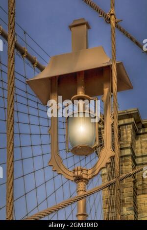 Brooklyn Bridge Lamp - Nahem Blick auf eine alte Straßenlampe auf der Brooklyn Bridge sowie auf die Details der historischen und ikonischen Brücke in Lower M Stockfoto