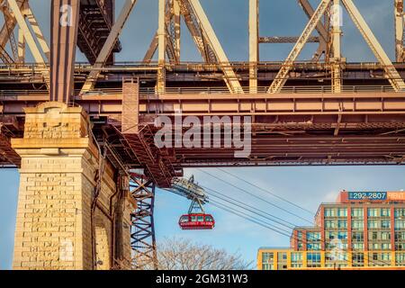 Roosevelt Tram unter der 59 St Bridge - Blick unter der Ed Koch 59th Street Queensboro Bridge mit der roten Roosevelt Island Straßenbahn. Stockfoto