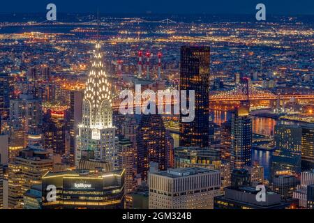 Chrysler Building NYC Twilight - Blick von oben auf die beleuchtete Skyline von Midtown Manhattan, einschließlich des legendären Art déco-Chrysler-Gebäudes und des T-Gebäudes Stockfoto