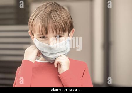 Gesundheitswesen. Gesichtsmaske zum Schutz des Coronavirus-Ausbruchs. Kind trägt eine Arznei Maske im Freien Stockfoto