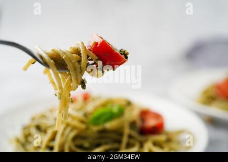 Hausgemachte Pesto-Pasta mit Spaghetti-Kirschtomaten und Parmesankäse Stockfoto