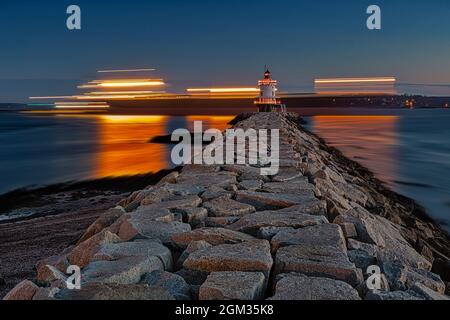 ASpring Point Ledge Light - Ein Schiff segelt hinter dem Spring Point Ledge Lighthouse in South Portland, Maine vorbei. Stockfoto