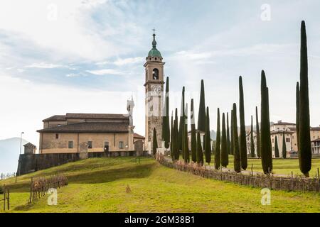 Ansicht der Kirche Sant Abbondio, umgeben von hohen Zypressen in Gentilino, in der Gemeinde Collina d'Oro, Bezirk Lugano im Kanton Tici Stockfoto