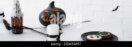 Gebackene halloween-Kekse in der Nähe von geschnitzten Kürbis und Kerzen, Banner Stockfoto