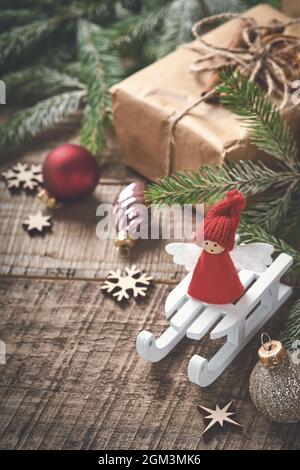 Lustige Weihnachtsengel Tannenzweige und Geschenkboxen auf winterverschneiten Hintergrund mit verschneiten Ästen. Weihnachts- oder Winterkonzept. Stockfoto