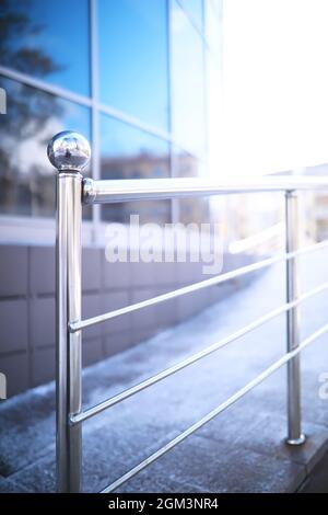 Geländer aus Glas und Edelstahl. Treppe im modernen Interieur. Glasgeländer. Niedriger Winkel Blick auf Treppen, die in Richtung eines modernen Gebäudes führen. Stockfoto