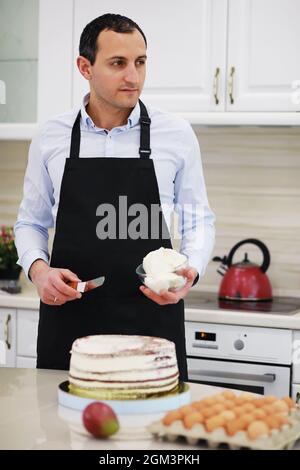 Master Konditor vor einem Schreibtisch. Kochen Desserts zu Hause. Der armenische Mann beschäftigte sich mit der Süßwaren. Stockfoto