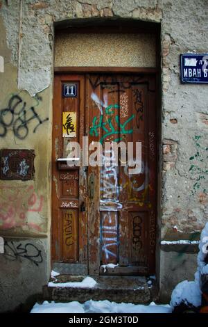 Alte Stadt Holztür mit Graffiti gefüllt Stockfoto