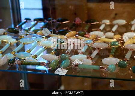 Gesichtsmassager Mit Grünem, Blauem, Rosa, Gelbem Und Weißem Rollquarz Stockfoto