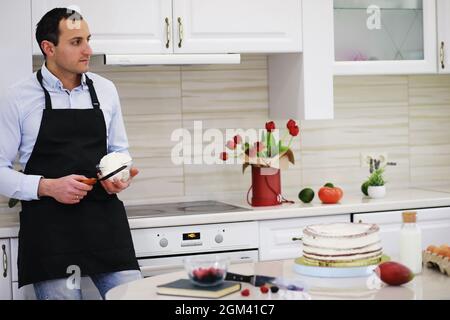 Master Konditor vor einem Schreibtisch. Kochen Desserts zu Hause. Der armenische Mann beschäftigte sich mit der Süßwaren. Stockfoto