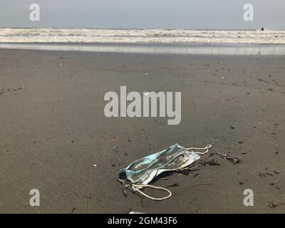 Chirurgische Maske auf Cox Bazar Strand, auf Wasserverschmutzung Konzept. Stockfoto